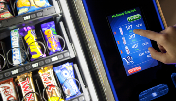 Person using a touch screen to place an order on a vending machine